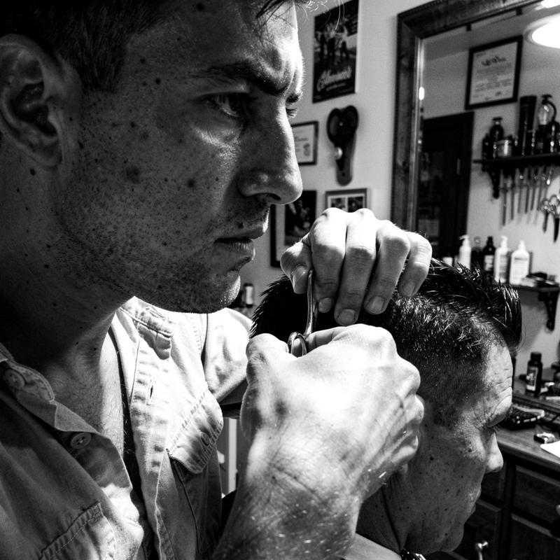Male barber portrait cropped at the jawline, focused expression